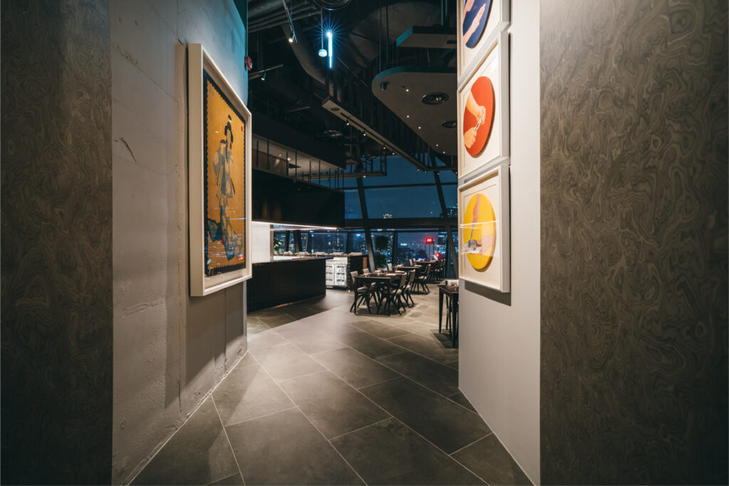 Stylish private room Kuala Lumpur setting with framed art, city views and a modern dining space for business meals.